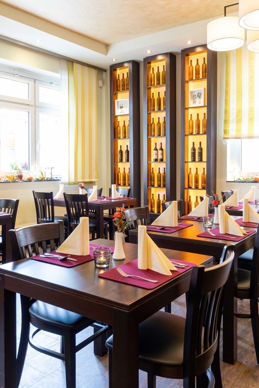 Gastraum im Gasthaus Stern mit festlich eingedeckten Tischen und beleuchteten Weinregalen